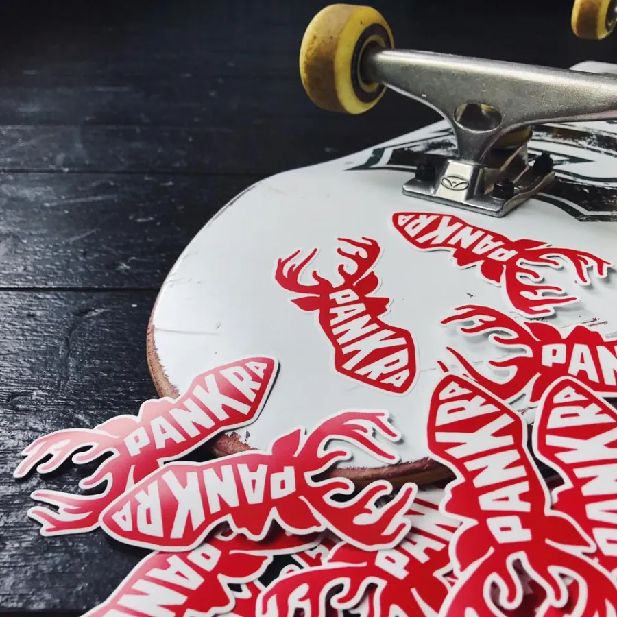Merchandise, eigen werk Pankra: stickers met het hert, op een skateboard